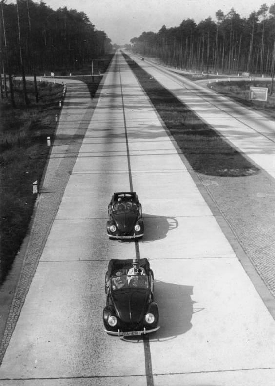 第二次大戦期のアウトバーンを走行する2台のKdFワーゲン(後のフォルクスワーゲン)。KdFは小型車ながらアウトバーンを100km/h連続巡航可能に設計され、1938年から戦時中にかけて少数が先行して限定製造された。短いスパンで打設されたコンクリート舗装が観察できる。1943年撮影