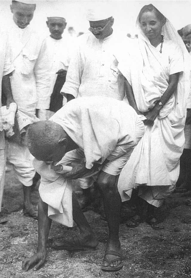 1930年4月5日、泥と塩の塊を持ち上げるマハトマ・ガンディー